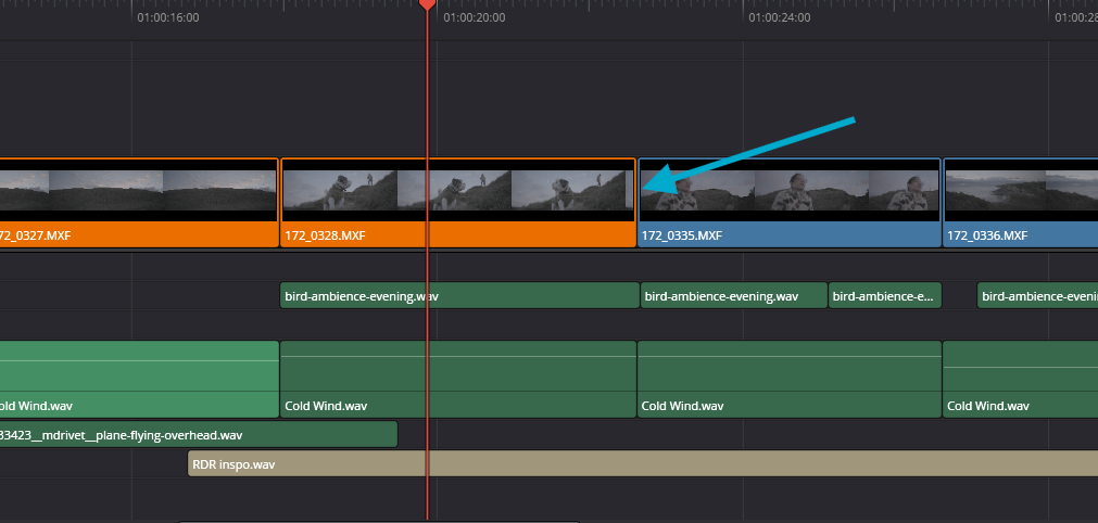 A screenshot of a standard cut on a video timeline, highlighted by a blue arrow, in DaVinci Resolve