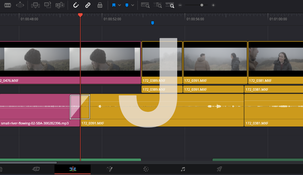  A screenshot of an example of a J-cut on a video editing timeline in DaVInci Resolve with a J overlaid on top for visibility.
