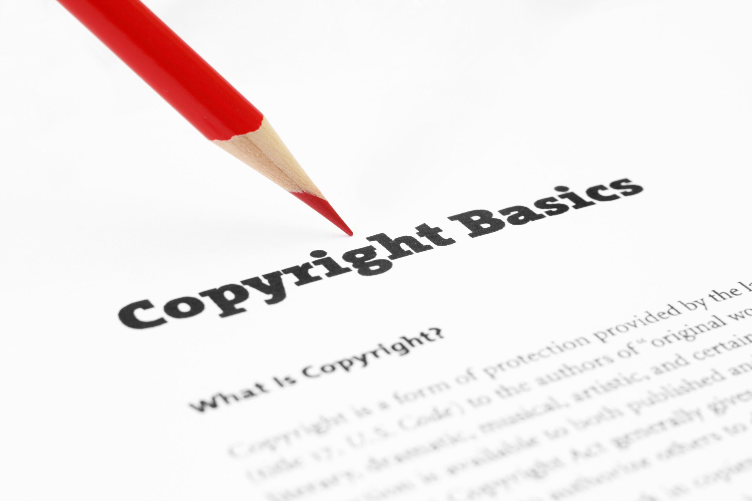 Copyright basics for free stock photos for commercial use. Image of a red pencil on top of a sheet of paper with Copyright Basics shown in black text up top and What is copyright beneath that.