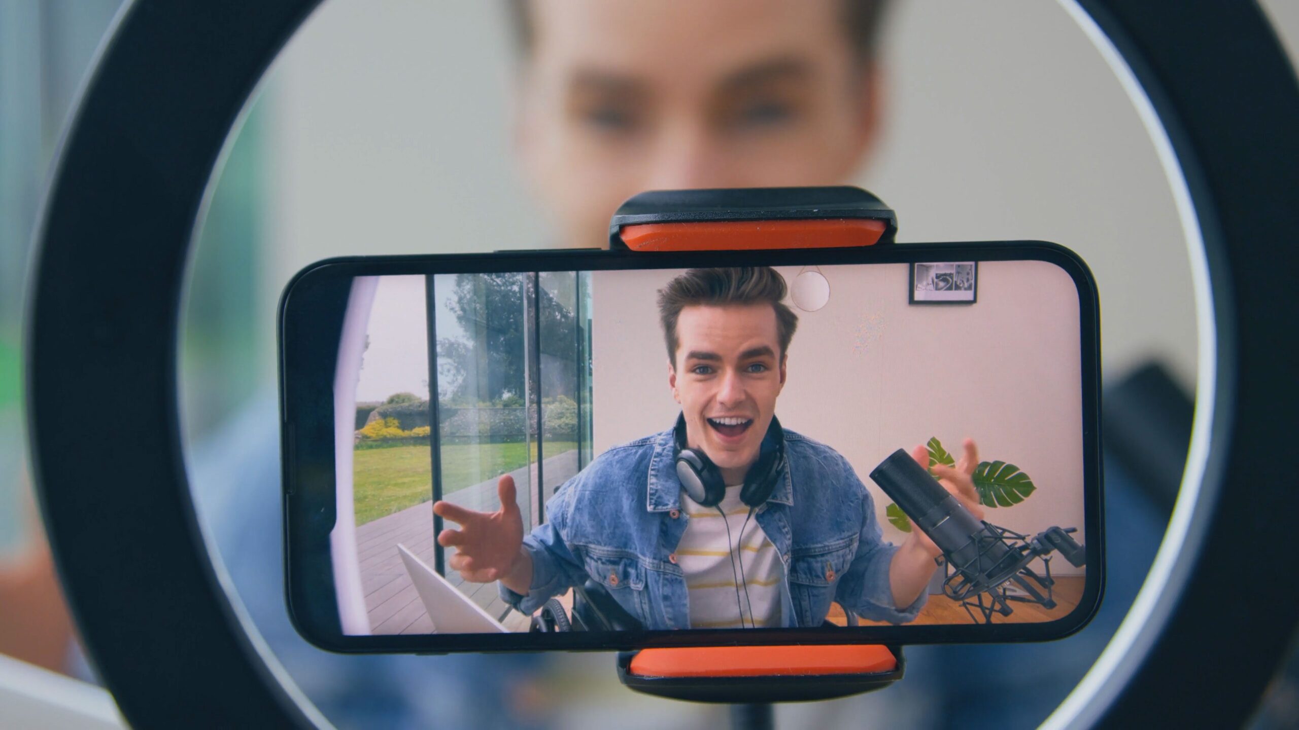 Image of man filming with his phone and a ring light. The evolution of short form video marketing. Intro music for YouTube