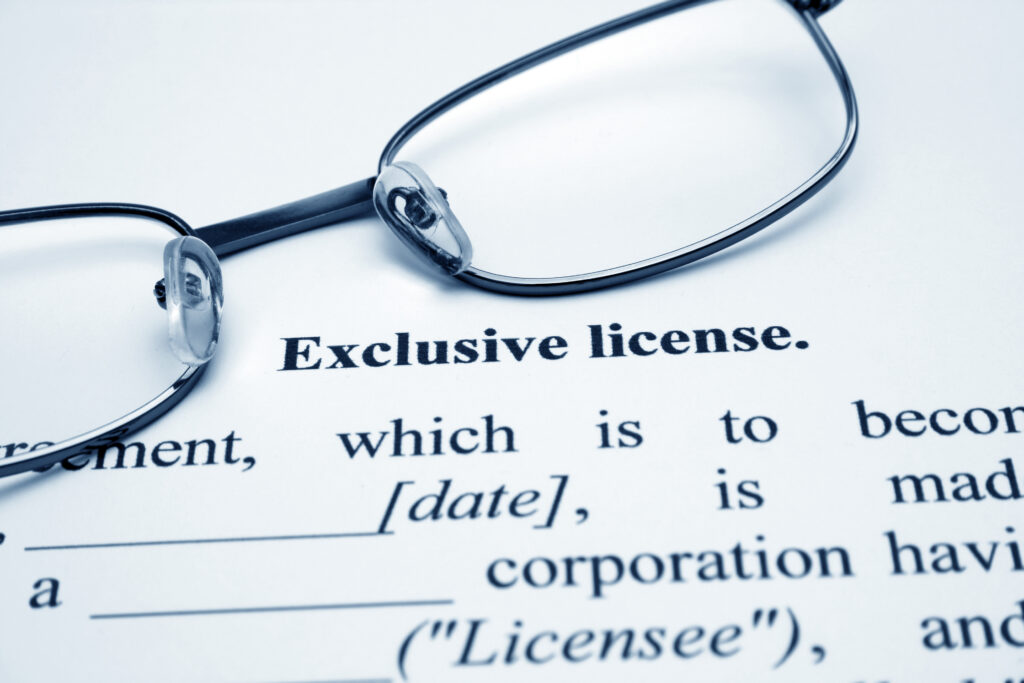 Image of a glasses on top of a paper with terms for an exclusive license