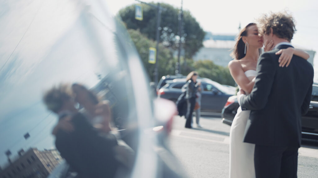 Still Image of Beautiful Newlyweds In Reflection Of Car Action Newlyweds Are Hugging On City Street With Reflection In Car Windows Reflection In Car
